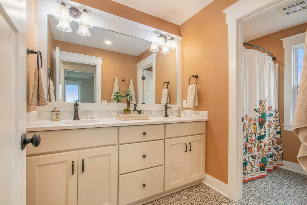 Пример оригинального дизайна: ванная комната в стиле неоклассика (современная классика) с фасадами в стиле шейкер, бежевыми фасадами, ванной в нише, душем над ванной, раздельным унитазом, разноцветной плиткой, мраморной плиткой, оранжевыми стенами, полом из винила, врезной раковиной, шторкой для ванной и белой столешницей