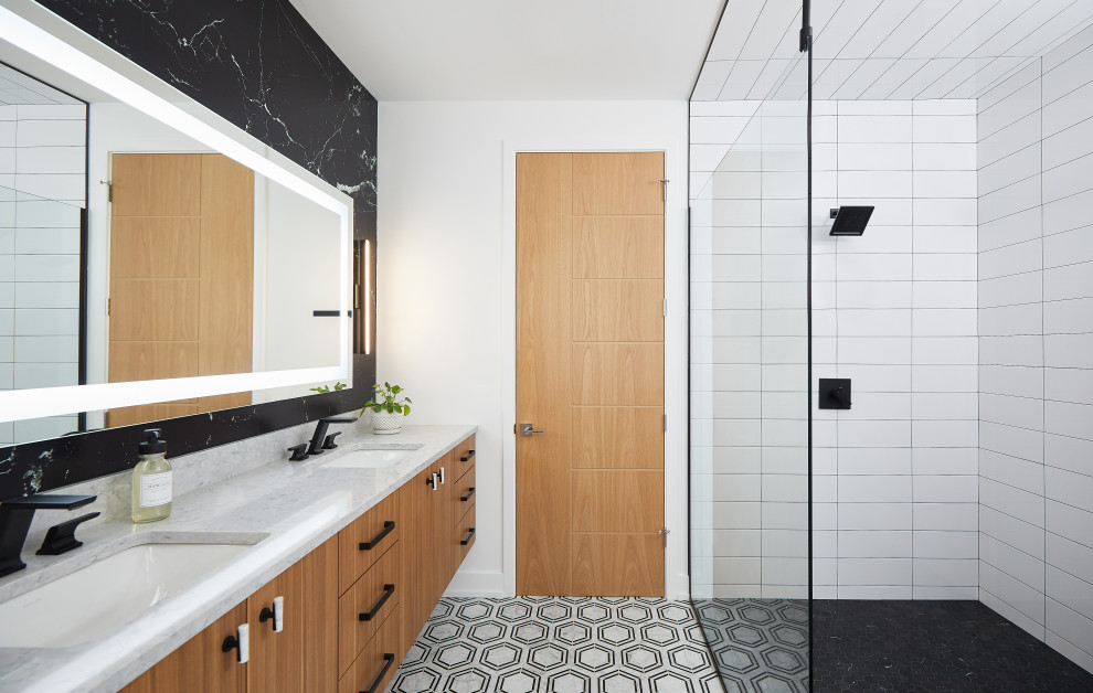 Large contemporary ensuite bathroom in Grand Rapids with flat-panel cabinets, medium wood cabinets, a built-in shower, black and white tiles, stone slabs, white walls, a submerged sink, engineered stone worktops, grey floors, an open shower, grey worktops, double sinks and a floating vanity unit.