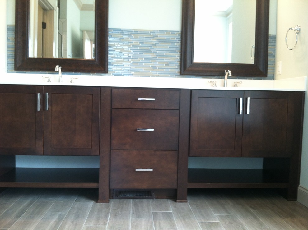 Arts and crafts master blue tile and glass tile ceramic tile bathroom photo in Raleigh with an integrated sink, shaker cabinets, dark wood cabinets, solid surface countertops and blue walls