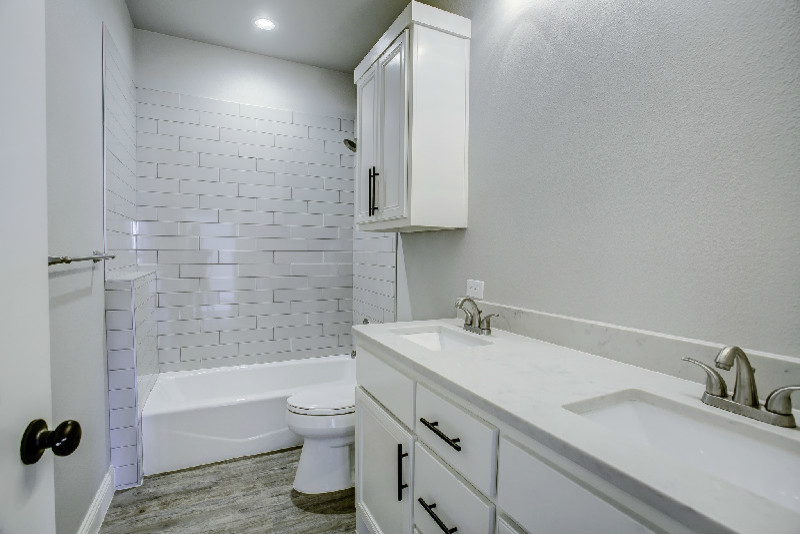 Mid-sized southwest kids' white tile and subway tile medium tone wood floor bathroom photo in Austin with beige walls, flat-panel cabinets, white cabinets, a two-piece toilet, an undermount sink and quartz countertops