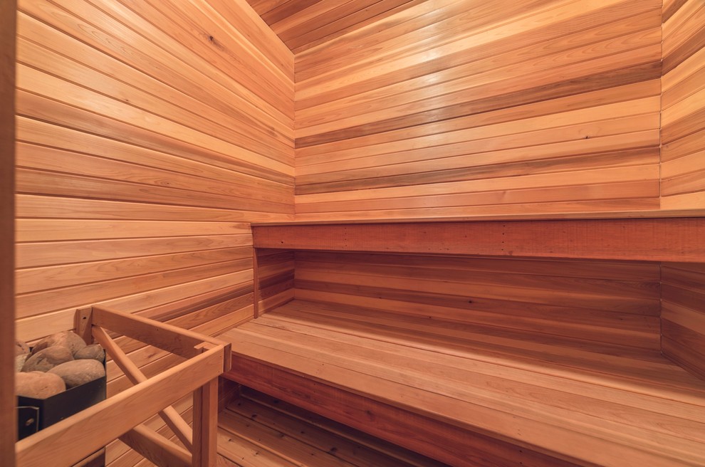 Idée de décoration pour un sauna chalet de taille moyenne avec une baignoire en alcôve, un combiné douche/baignoire, un mur marron, un sol en bois brun, un plan vasque, un sol marron et aucune cabine.