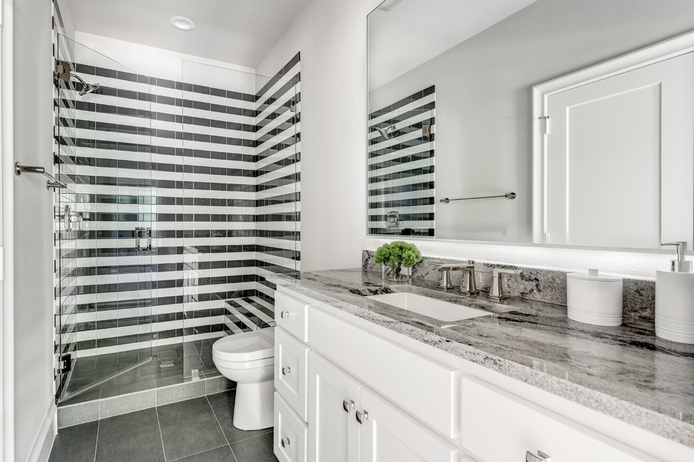 Photo of a large mediterranean family bathroom in Dallas with shaker cabinets, white cabinets, a walk-in shower, a two-piece toilet, black and white tiles, metro tiles, white walls, porcelain flooring, a submerged sink, granite worktops, grey floors, a hinged door and grey worktops.