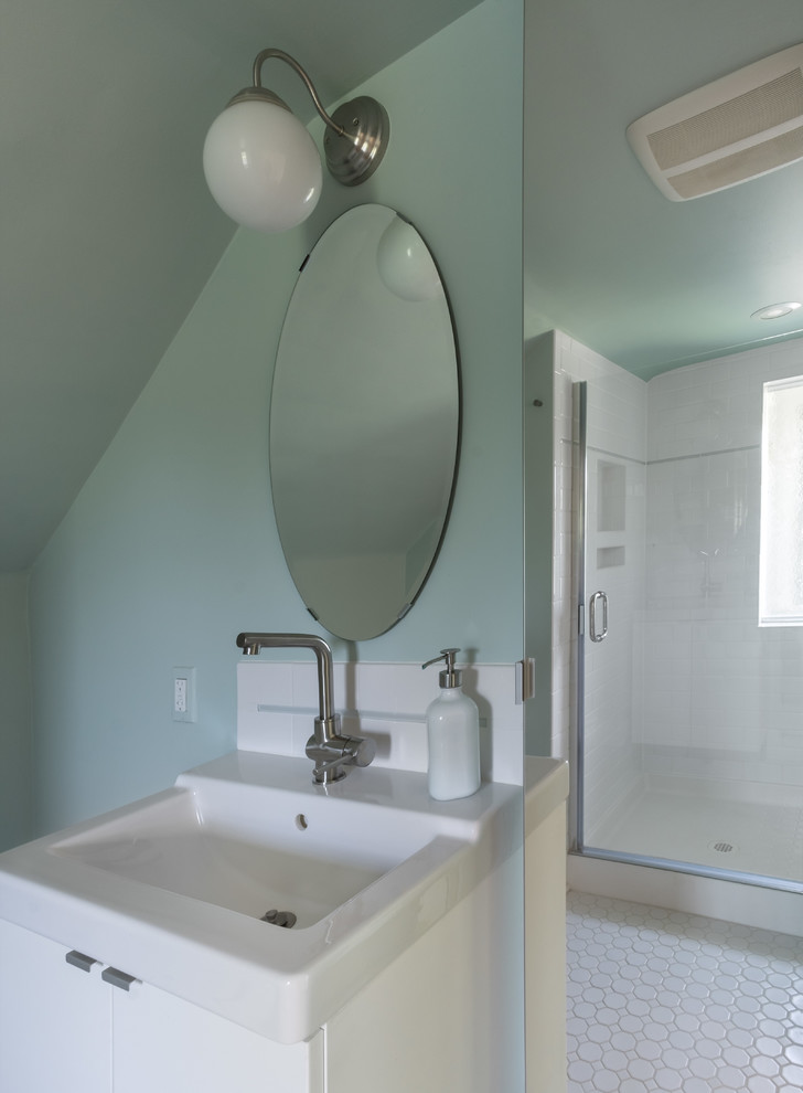 Bild på ett mellanstort retro badrum med dusch, med släta luckor, vita skåp, en dusch i en alkov, gröna väggar, klinkergolv i keramik, vitt golv, dusch med gångjärnsdörr, vit kakel, porslinskakel och ett nedsänkt handfat