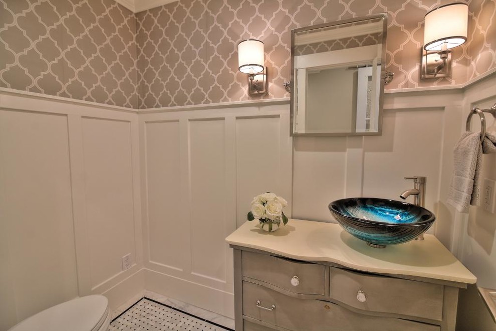 Diseño de cuarto de baño de estilo americano con armarios tipo mueble, puertas de armario con efecto envejecido, sanitario de una pieza, paredes blancas, suelo con mosaicos de baldosas, lavabo sobreencimera y suelo blanco