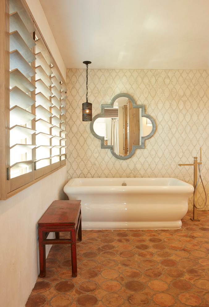 На фото: главная ванная комната среднего размера в морском стиле с отдельно стоящей ванной, бежевой плиткой, керамической плиткой, бежевыми стенами, полом из терракотовой плитки и оранжевым полом с