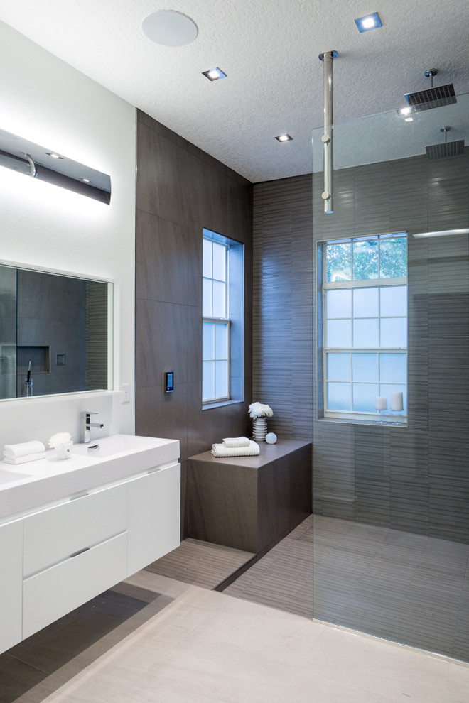 Inspiration för mellanstora moderna en-suite badrum, med släta luckor, vita skåp, ett fristående badkar, en öppen dusch, brun kakel, porslinskakel, vinylgolv, ett integrerad handfat, bänkskiva i akrylsten, grå väggar, beiget golv och med dusch som är öppen