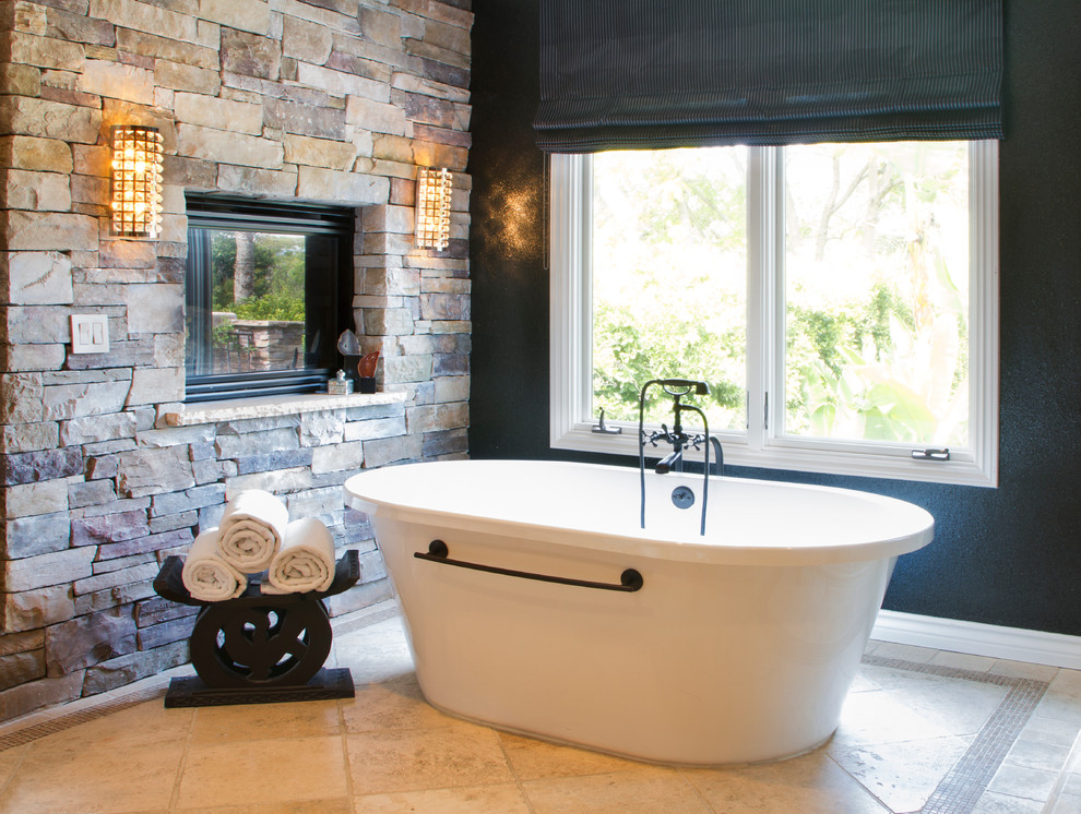 Стильный дизайн: большая главная ванная комната в стиле неоклассика (современная классика) с отдельно стоящей ванной, бежевой плиткой, каменной плиткой, черными стенами и полом из травертина - последний тренд