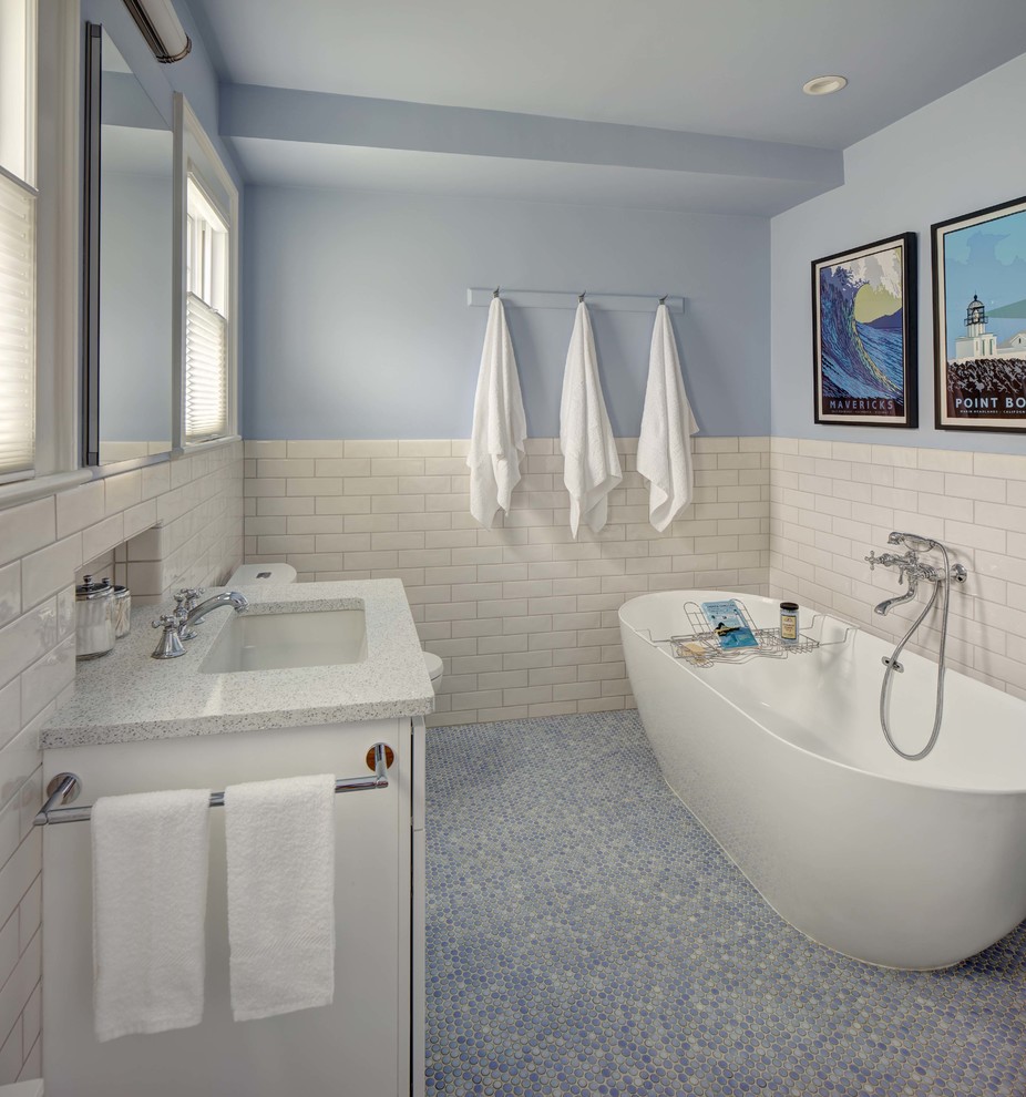 Cette image montre une salle de bain principale traditionnelle de taille moyenne avec des portes de placard blanches, une baignoire indépendante, un carrelage blanc, des carreaux de céramique, un mur bleu, un lavabo encastré, un plan de toilette en quartz modifié, un sol bleu, un plan de toilette blanc et un sol en carrelage de terre cuite.