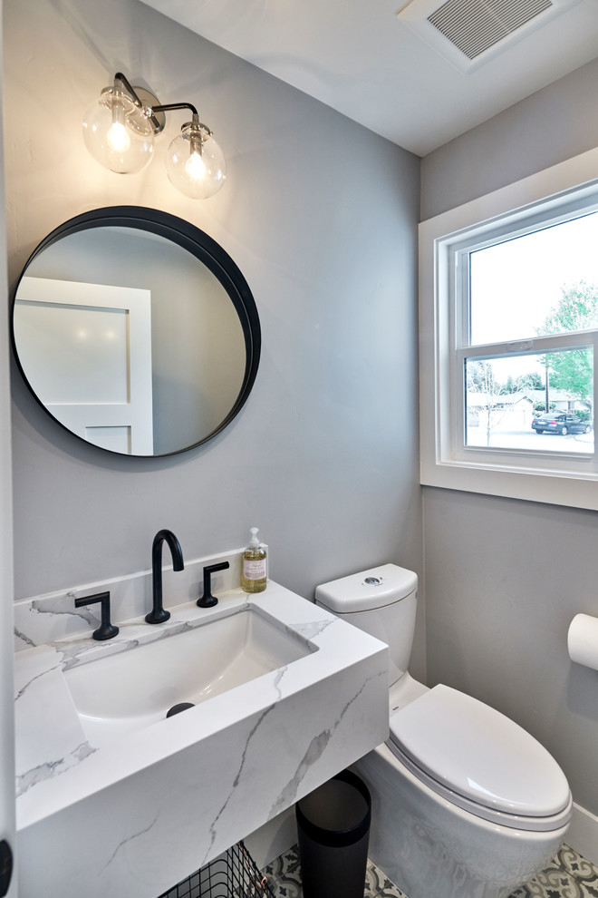 Bild på ett lantligt badrum med dusch, med en toalettstol med separat cisternkåpa, grå väggar, klinkergolv i keramik, ett nedsänkt handfat, marmorbänkskiva och grått golv