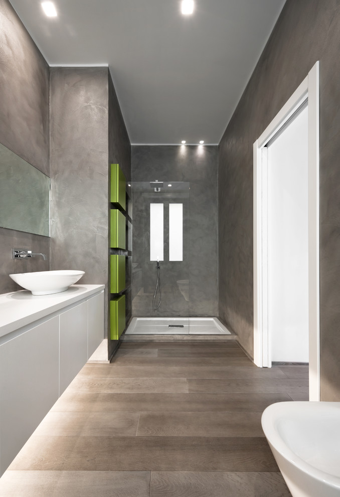 ローマにあるコンテンポラリースタイルのおしゃれな浴室 (ベッセル式洗面器、フラットパネル扉のキャビネット、白いキャビネット、アルコーブ型シャワー、グレーの壁) の写真