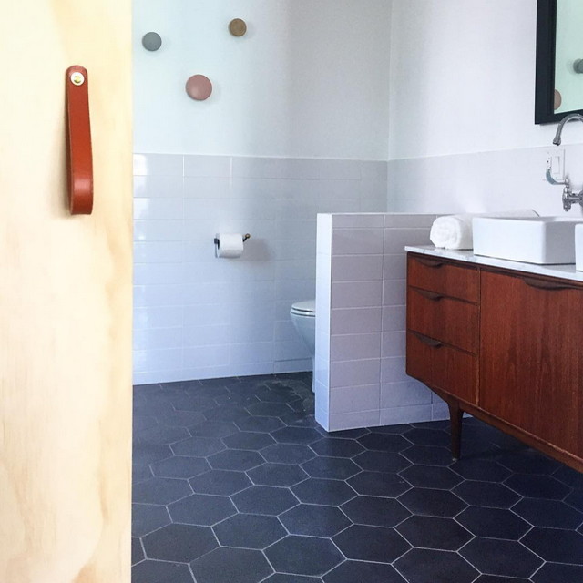 Diseño de cuarto de baño contemporáneo con lavabo sobreencimera, puertas de armario de madera oscura, encimera de mármol, baldosas y/o azulejos negros, baldosas y/o azulejos de cemento y paredes blancas