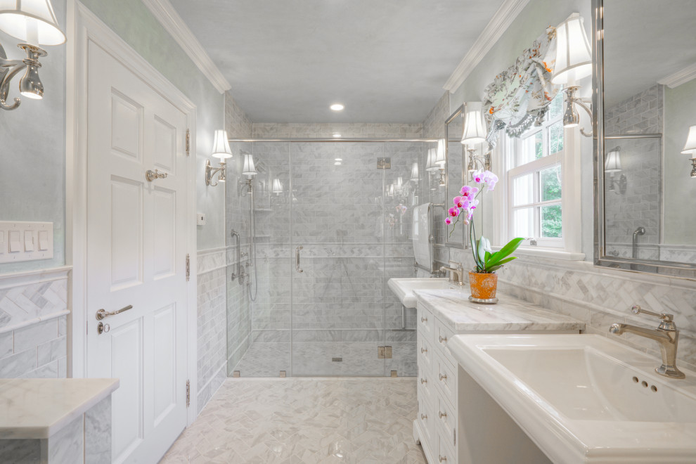 Inredning av ett klassiskt mellanstort vit vitt en-suite badrum, med luckor med infälld panel, vita skåp, en kantlös dusch, grå kakel, marmorkakel, marmorgolv, ett piedestal handfat, marmorbänkskiva, grått golv, dusch med gångjärnsdörr och grå väggar