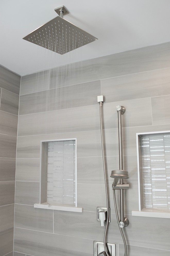 This is an example of a large contemporary ensuite bathroom in Philadelphia with raised-panel cabinets, white cabinets, a freestanding bath, a corner shower, grey tiles, porcelain tiles, grey walls, vinyl flooring, a submerged sink, marble worktops, brown floors and a hinged door.