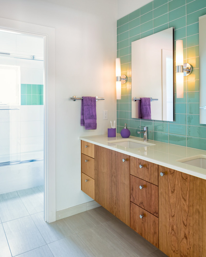 Ejemplo de cuarto de baño actual con lavabo bajoencimera, armarios con paneles lisos, puertas de armario de madera en tonos medios, bañera encastrada, paredes blancas y espejo con luz
