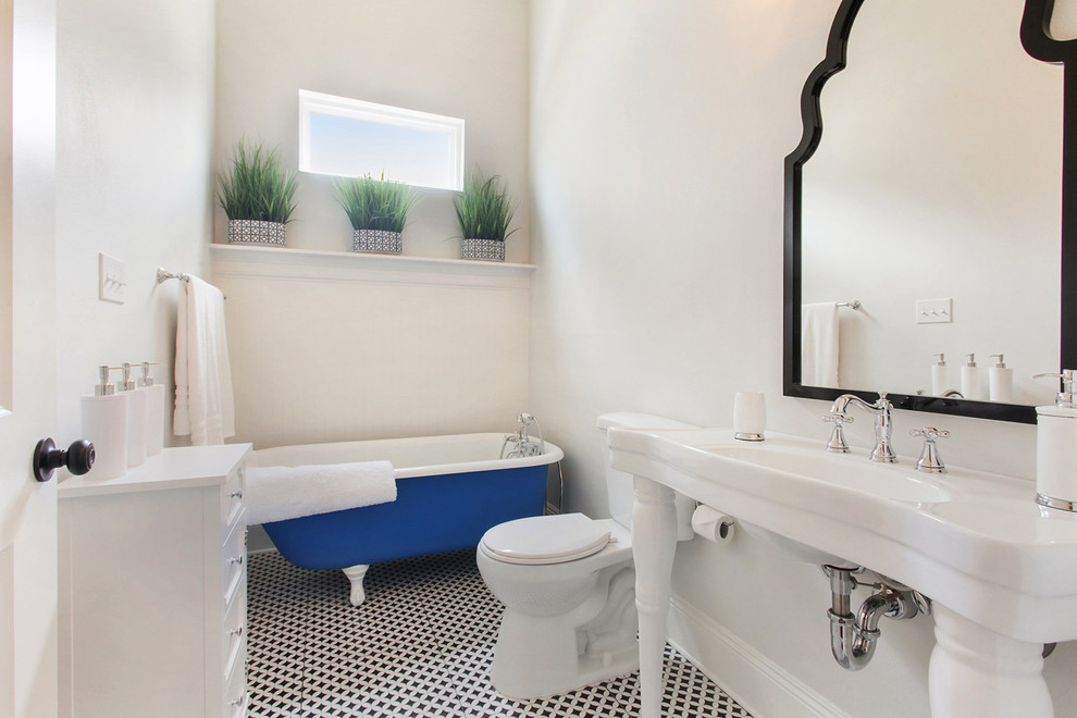 Example of a classic 3/4 black floor claw-foot bathtub design in New Orleans with a pedestal sink, recessed-panel cabinets, white cabinets, a two-piece toilet, white walls and white countertops