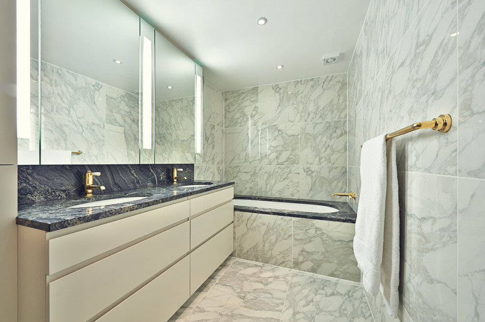 Modernes Badezimmer En Suite mit Unterbauwaschbecken, flächenbündigen Schrankfronten, weißen Schränken, Unterbauwanne, farbigen Fliesen und Marmorboden in London