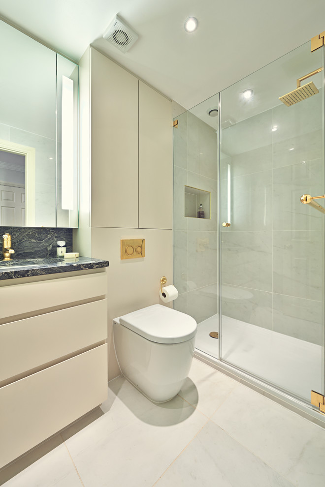 ロンドンにあるコンテンポラリースタイルのおしゃれなバスルーム (浴槽なし) (アンダーカウンター洗面器、フラットパネル扉のキャビネット、ベージュのキャビネット、アルコーブ型シャワー、壁掛け式トイレ、グレーのタイル) の写真