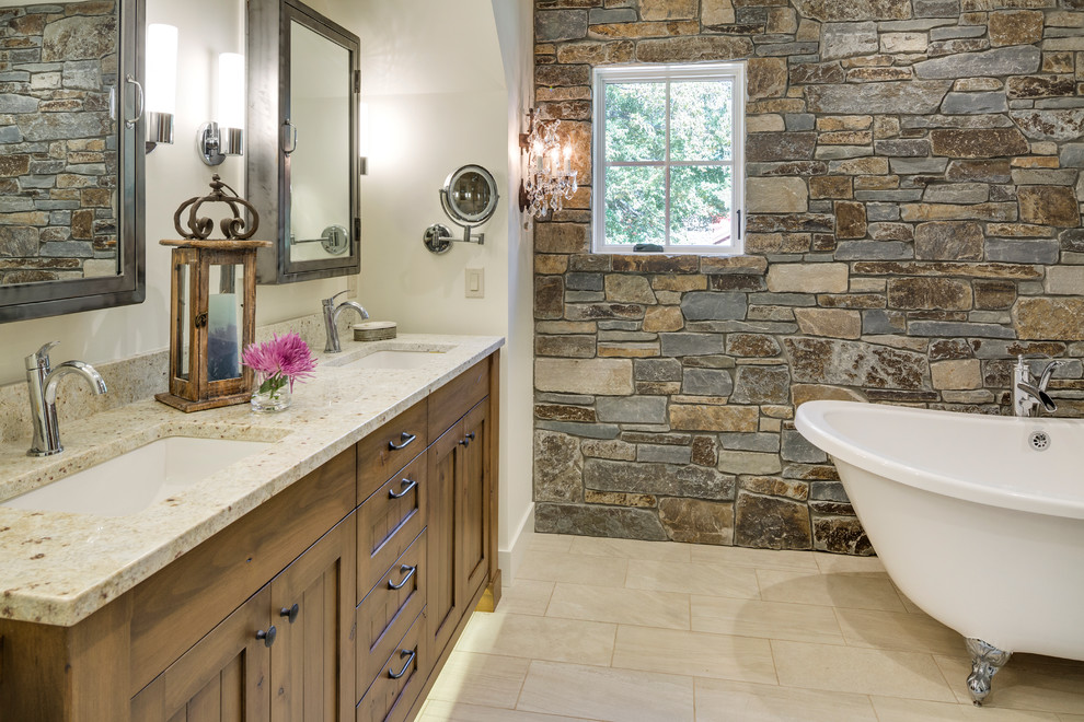 Foto på ett rustikt en-suite badrum, med ett undermonterad handfat, skåp i mellenmörkt trä, ett badkar med tassar, vit kakel, klinkergolv i porslin, vita väggar och luckor med infälld panel