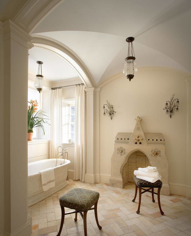 Imagen de cuarto de baño principal tradicional grande con bañera exenta, paredes beige y suelo de piedra caliza