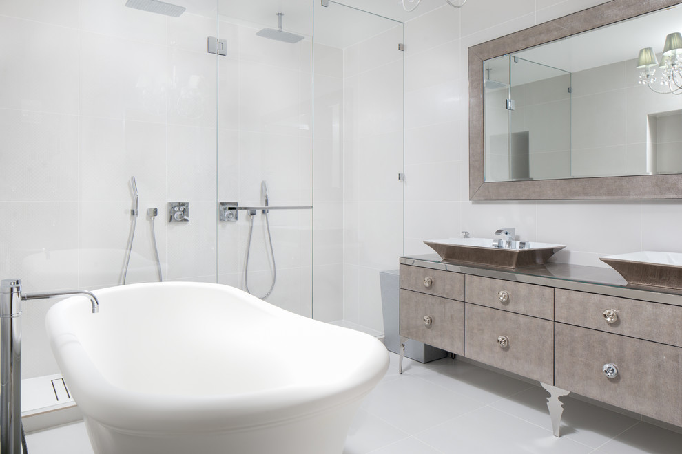 Medium sized modern ensuite bathroom in New York with freestanding cabinets, medium wood cabinets, a freestanding bath, a double shower, a one-piece toilet, white tiles, ceramic tiles, white walls, ceramic flooring, a vessel sink, glass worktops, beige floors, a hinged door and turquoise worktops.