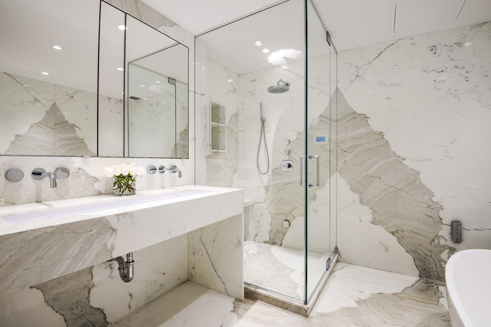Cette image montre une salle de bain principale design de taille moyenne avec une baignoire indépendante, une douche d'angle, du carrelage en marbre, un mur blanc, un sol en marbre, une grande vasque, un plan de toilette en marbre, un sol blanc, une cabine de douche à porte battante et un plan de toilette blanc.