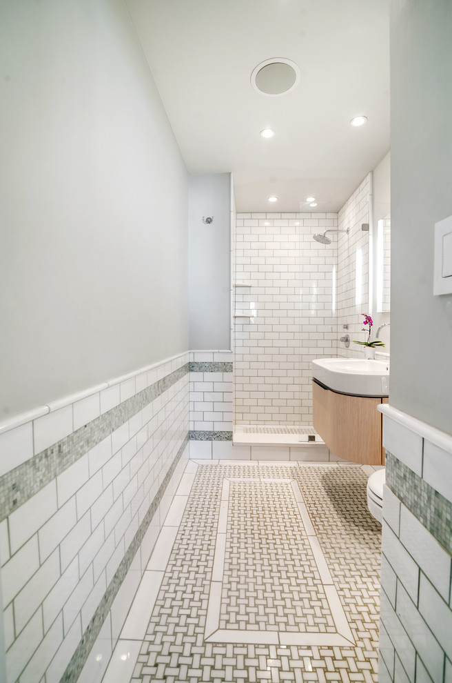 Idéer för ett litet modernt en-suite badrum, med möbel-liknande, skåp i ljust trä, en dusch i en alkov, en vägghängd toalettstol, vit kakel, tunnelbanekakel, gröna väggar, mosaikgolv, ett integrerad handfat och bänkskiva i akrylsten