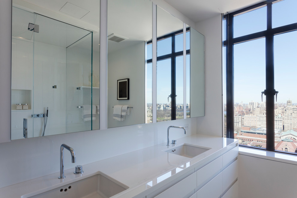 На фото: большая главная ванная комната в современном стиле с плоскими фасадами, белыми фасадами, открытым душем, унитазом-моноблоком, белой плиткой, плиткой из листового стекла, белыми стенами и врезной раковиной с