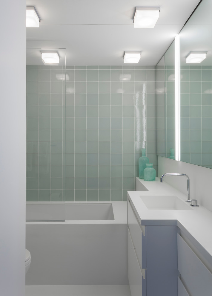 Example of a large trendy master green tile and glass tile alcove bathtub design in New York with raised-panel cabinets, white cabinets, white walls and an undermount sink