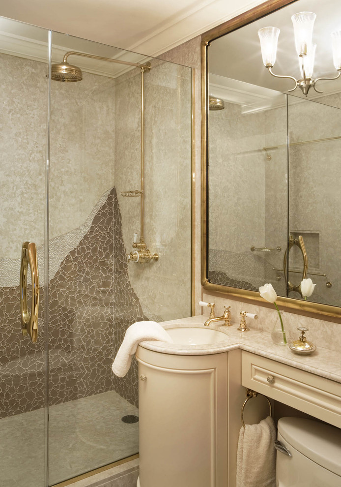 Photo of a medium sized classic ensuite bathroom in New York with a submerged sink, beaded cabinets, beige cabinets, marble worktops, a one-piece toilet, beige tiles, glass tiles, beige walls and marble flooring.