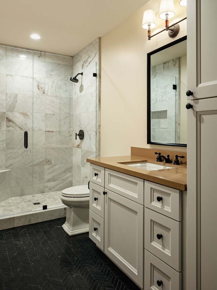 Inspiration for a mid-sized transitional kids' beige tile and marble tile light wood floor and beige floor bathroom remodel in Phoenix with shaker cabinets, brown cabinets, a one-piece toilet, beige walls, an undermount sink, quartz countertops, a hinged shower door and black countertops