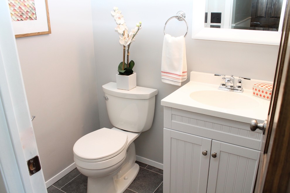 Modelo de cuarto de baño tradicional renovado pequeño con armarios con rebordes decorativos, puertas de armario blancas y paredes grises
