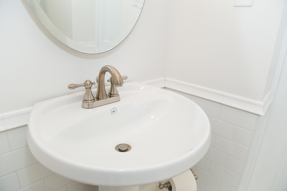 This is an example of a small modern bathroom in Calgary with a pedestal sink, a corner shower, a one-piece toilet, white tiles, metro tiles and white walls.