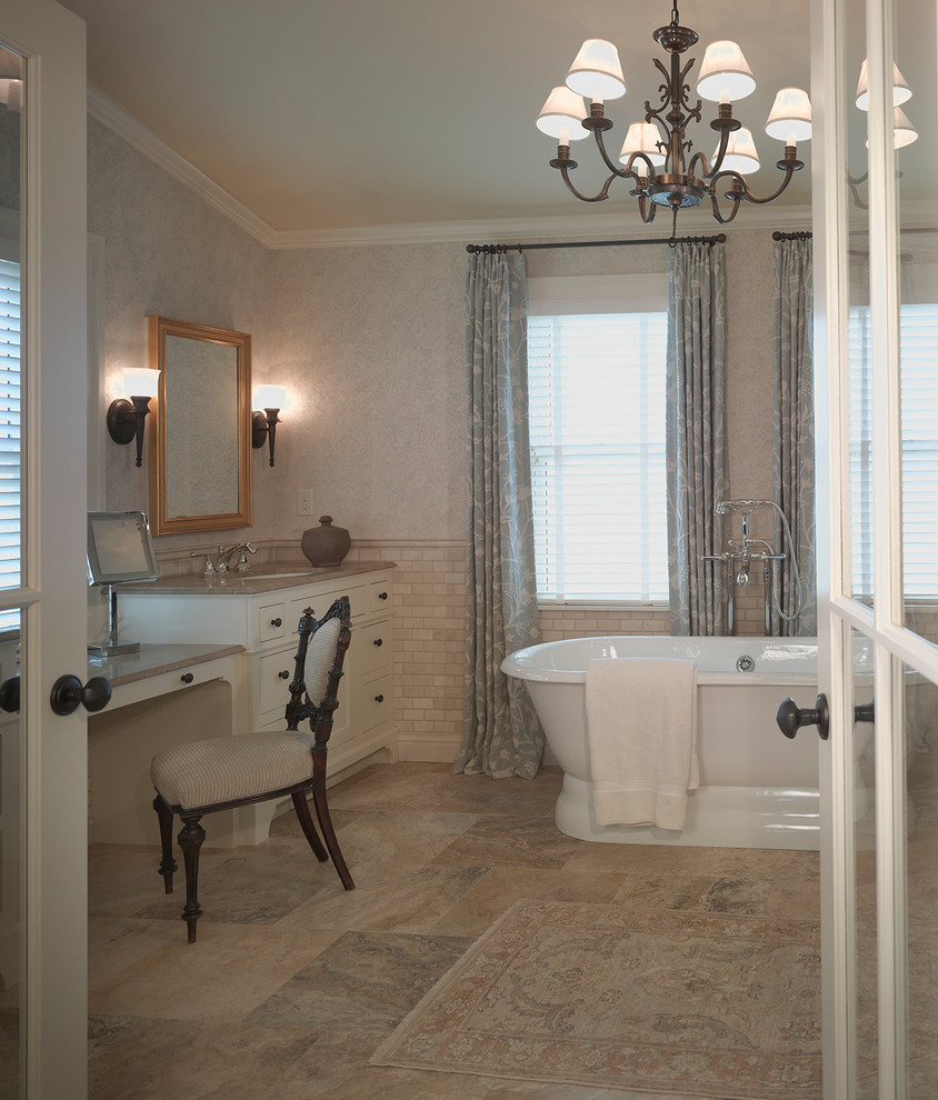 Photo of a traditional bathroom in Minneapolis with a submerged sink, white cabinets, a freestanding bath, beige tiles and metro tiles.