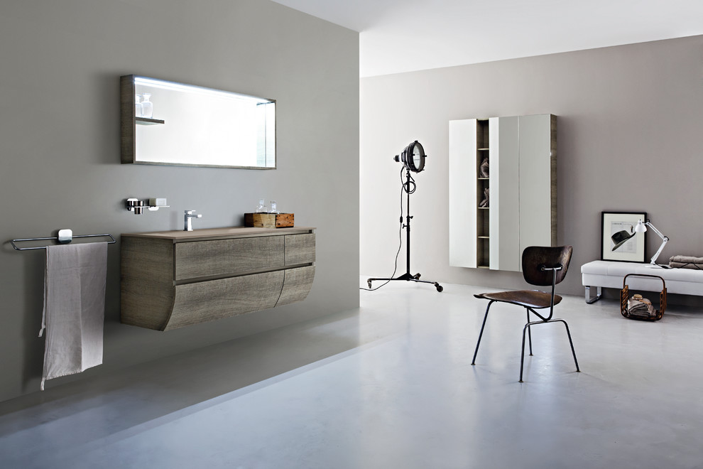 Ispirazione per una stanza da bagno contemporanea con ante lisce, ante in legno chiaro, pareti grigie, lavabo integrato e top in cemento