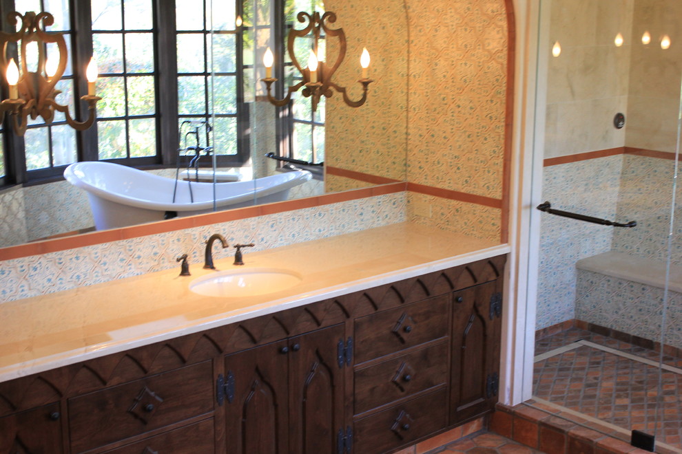 Example of a huge tuscan master multicolored tile and terra-cotta tile concrete floor bathroom design in San Diego with an undermount sink, recessed-panel cabinets, dark wood cabinets, marble countertops, a two-piece toilet and white walls