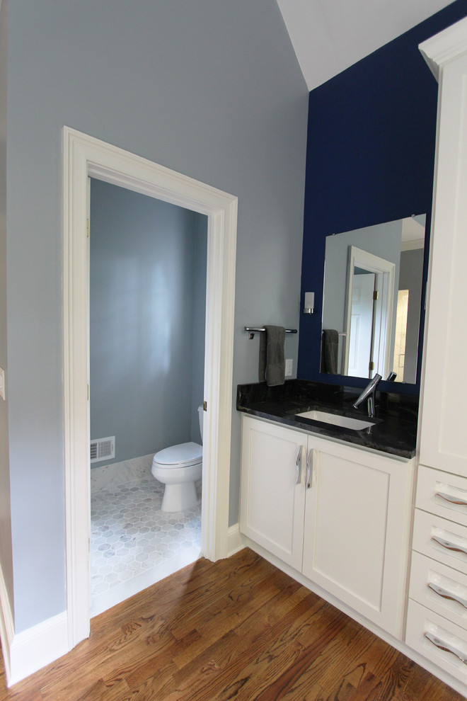 Idées déco pour un grand sauna classique avec un placard à porte shaker, des portes de placard blanches, une baignoire indépendante, WC séparés, un carrelage noir, un carrelage noir et blanc, un carrelage gris, un carrelage blanc, un carrelage de pierre, un mur bleu, parquet foncé, un lavabo encastré et un plan de toilette en granite.