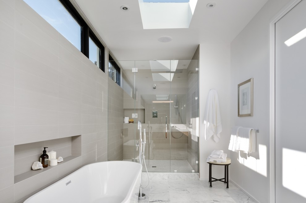 Ejemplo de cuarto de baño principal actual grande con bañera exenta, ducha empotrada, baldosas y/o azulejos grises, baldosas y/o azulejos de cerámica, paredes grises y suelo de mármol