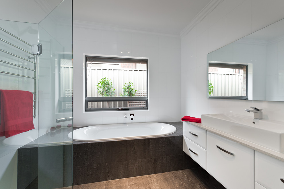 Foto di una stanza da bagno padronale minimalista di medie dimensioni con ante bianche, vasca da incasso, doccia alcova, piastrelle bianche e pareti bianche