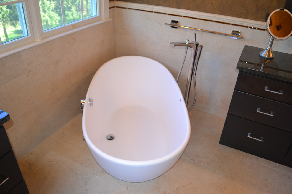 Inspiration for a large traditional ensuite bathroom in Philadelphia with a vessel sink, flat-panel cabinets, medium wood cabinets, granite worktops, a corner shower, a one-piece toilet, beige tiles, ceramic tiles, brown walls and ceramic flooring.
