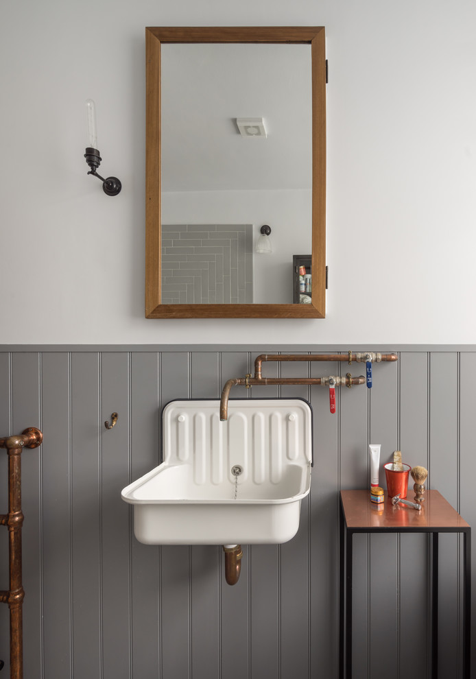 На фото: ванная комната в стиле лофт с серыми стенами и подвесной раковиной с