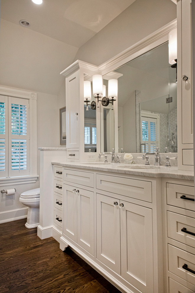 Exemple d'une grande salle de bain principale chic avec un placard à porte shaker, des portes de placard blanches, WC séparés, un mur gris, un sol en bois brun, un lavabo encastré, un sol marron et un plan de toilette gris.