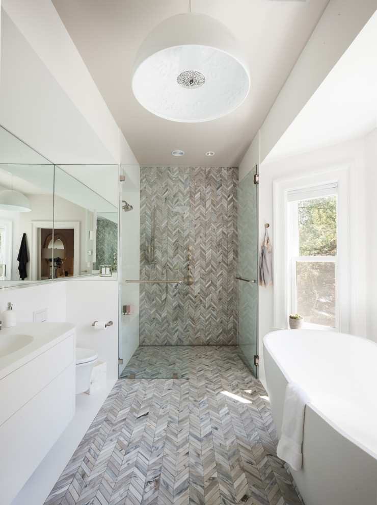 Стильный дизайн: ванная комната в современном стиле с плоскими фасадами, белыми фасадами, отдельно стоящей ванной, серой плиткой, плиткой мозаикой, белыми стенами, полом из мозаичной плитки, монолитной раковиной, серым полом, белой столешницей, тумбой под одну раковину и подвесной тумбой - последний тренд
