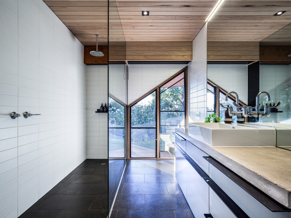 This is an example of a large contemporary bathroom in Melbourne with white cabinets, a walk-in shower, white walls, ceramic flooring and concrete worktops.