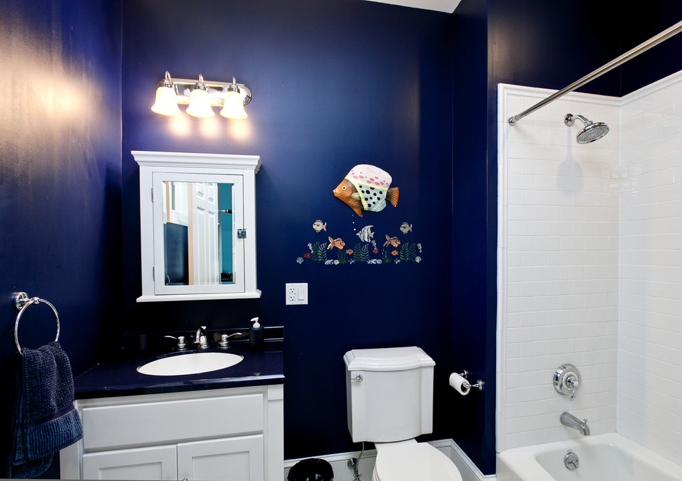 Imagen de cuarto de baño tradicional renovado pequeño con puertas de armario blancas, bañera esquinera, sanitario de dos piezas, baldosas y/o azulejos blancos, paredes azules y aseo y ducha
