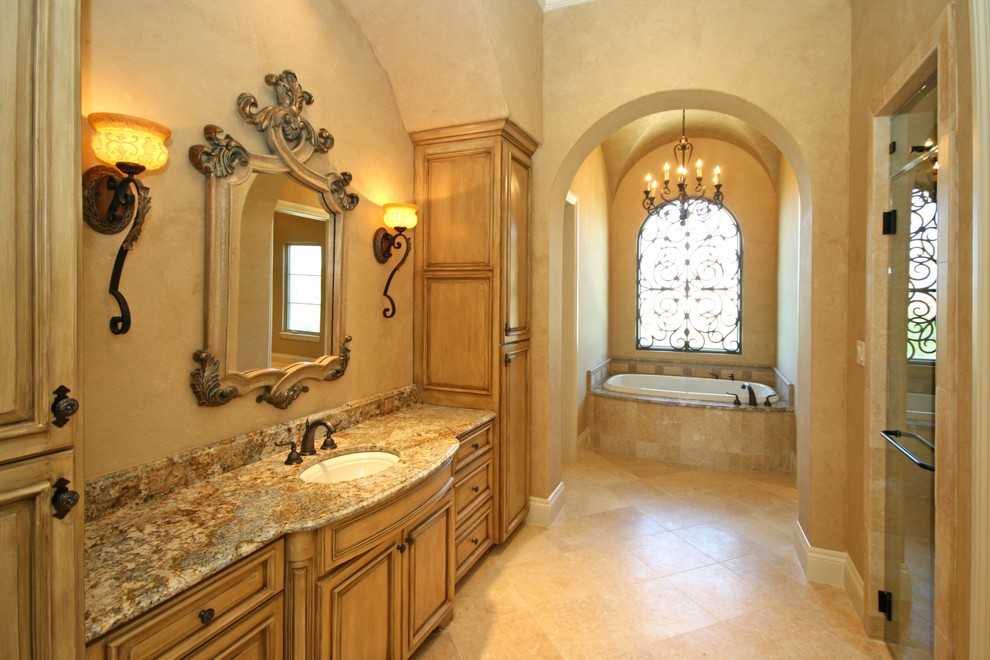 Bathroom - large traditional master porcelain tile and beige floor bathroom idea in Austin with raised-panel cabinets, light wood cabinets, beige walls, an undermount sink, granite countertops and a hinged shower door