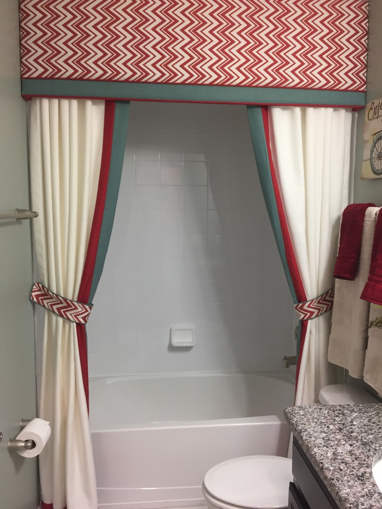 Klassisk inredning av ett litet badrum med dusch, med luckor med infälld panel, skåp i mörkt trä, ett badkar i en alkov, en dusch/badkar-kombination, en toalettstol med separat cisternkåpa, blå väggar, ett undermonterad handfat, granitbänkskiva, dusch med duschdraperi, vit kakel och keramikplattor