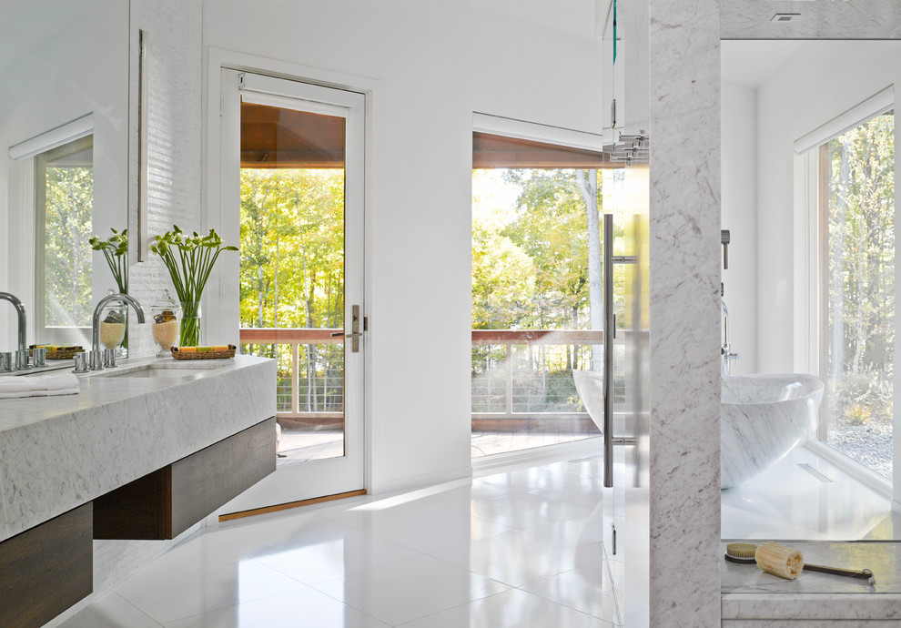 Example of a huge trendy master white tile white floor bathroom design in Burlington with flat-panel cabinets, white walls, an undermount sink, medium tone wood cabinets, a two-piece toilet, marble countertops and a hinged shower door