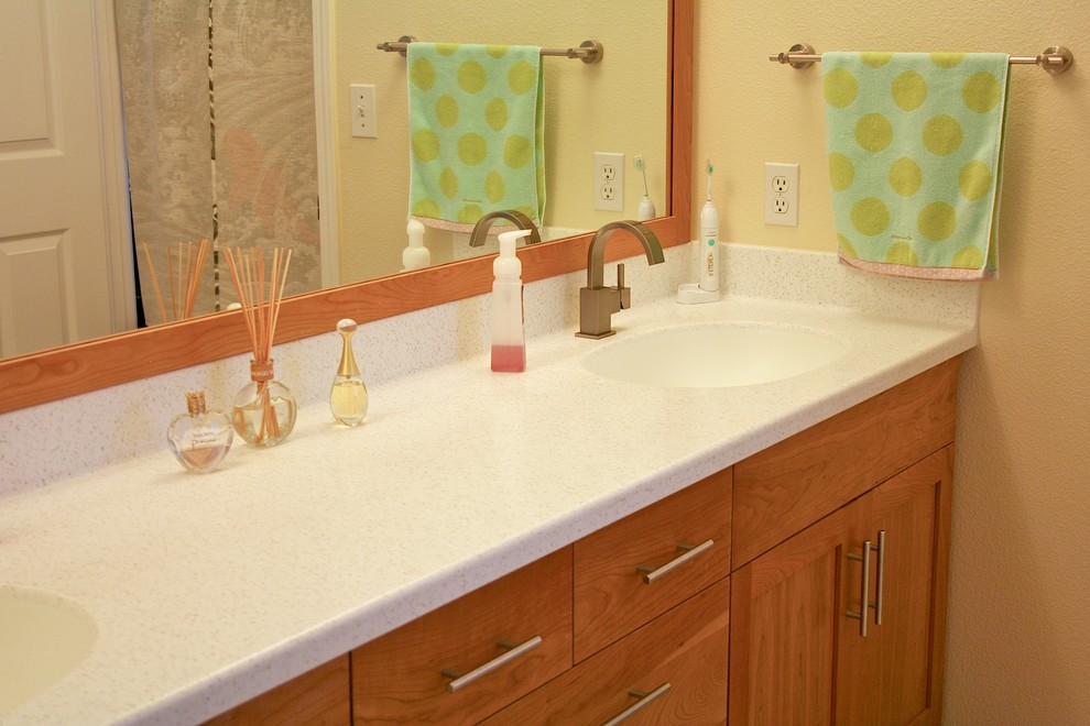 Immagine di una stanza da bagno design con lavabo integrato, ante in legno scuro, top in superficie solida, piastrelle beige, piastrelle in ceramica e pavimento con piastrelle in ceramica