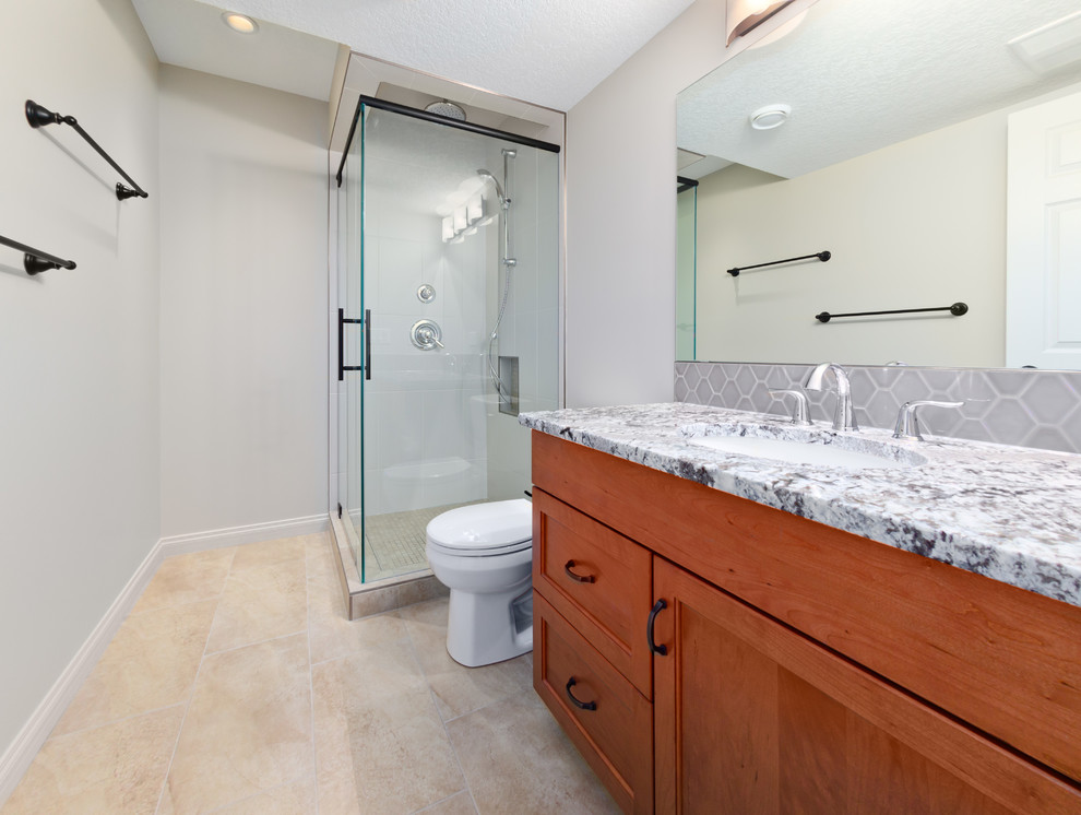 Exempel på ett mellanstort klassiskt badrum för barn, med ett undermonterad handfat, skåp i mellenmörkt trä, granitbänkskiva, en hörndusch, en toalettstol med separat cisternkåpa, vit kakel, keramikplattor, vita väggar och klinkergolv i keramik
