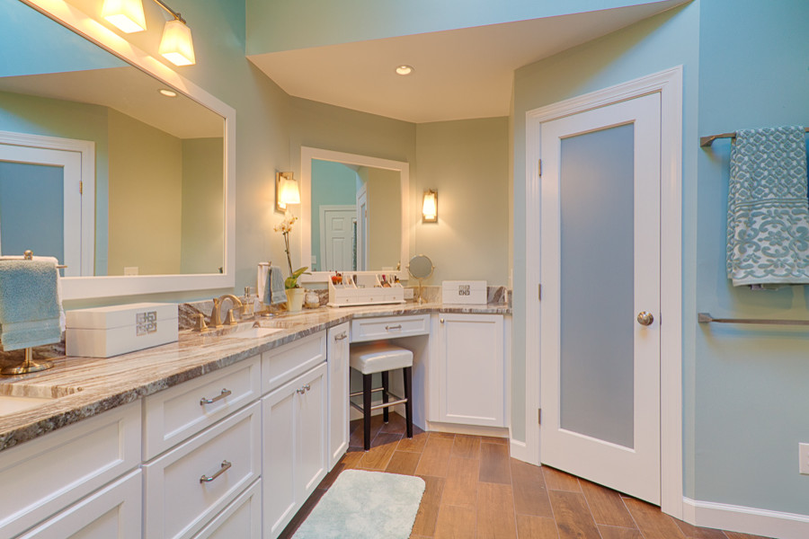 Large contemporary ensuite bathroom in Raleigh with a submerged sink, flat-panel cabinets, white cabinets, granite worktops, a freestanding bath, a corner shower, a two-piece toilet, brown tiles, porcelain tiles, blue walls and porcelain flooring.